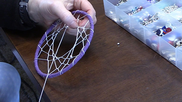 a homemade web of a dream catcher and adding some glass beads