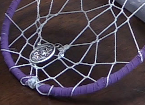 a medallion on the web of a dream catcher