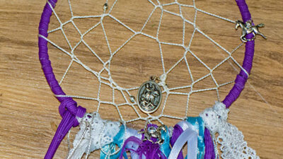 close up view of a homemade dream catcher with horse charms